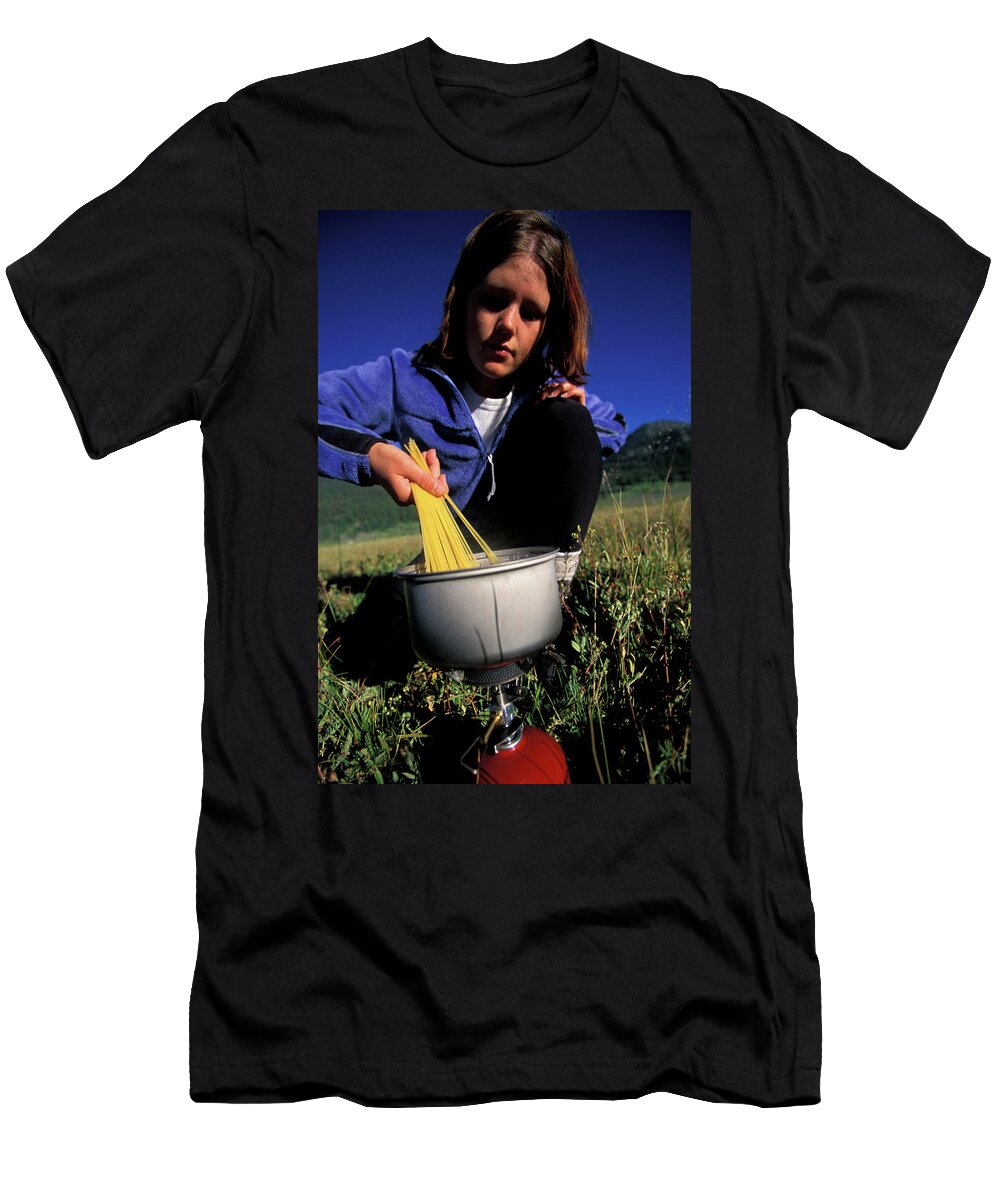 A Woman Cooking on Her Camp Stove Corey Rich T-Shirt